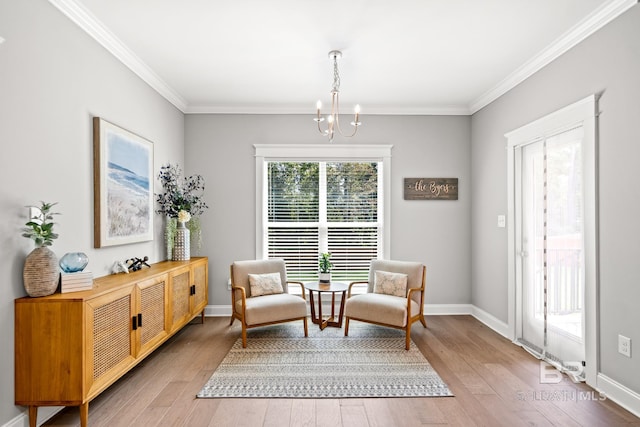 living area with crown molding, an inviting chandelier, and light wood-type flooring