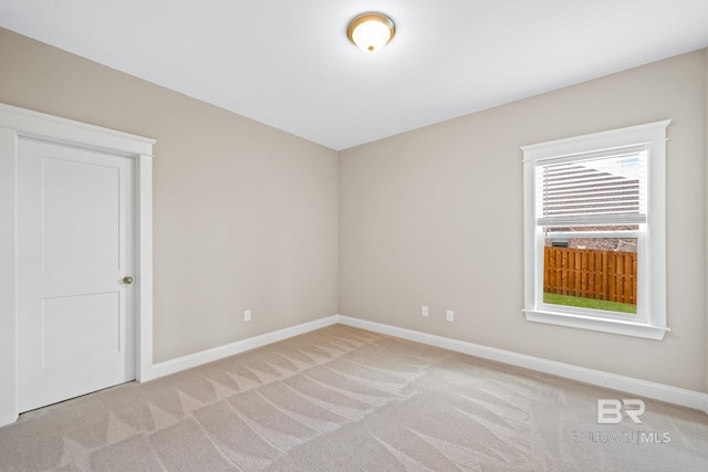 unfurnished room featuring light colored carpet