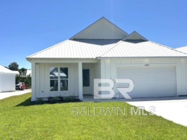 1257 Dorado Way, Gulf Shores, AL 36542 - view of front of home with an attached garage, a front yard, metal roof, and concrete driveway