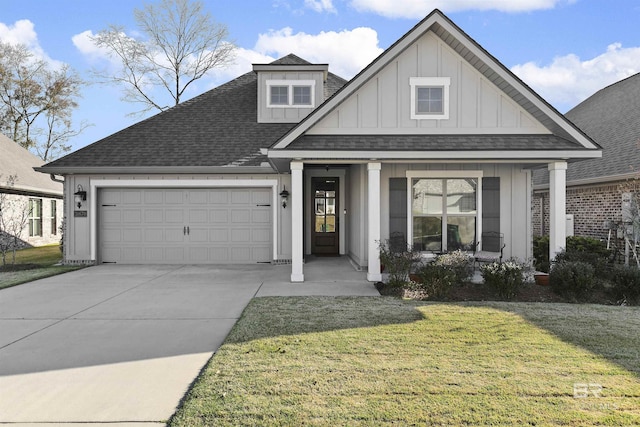 view of front facade featuring board and batten siding, a shingled roof, a front lawn, a garage, and driveway