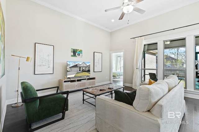 living room with ceiling fan, crown molding, baseboards, and wood finished floors