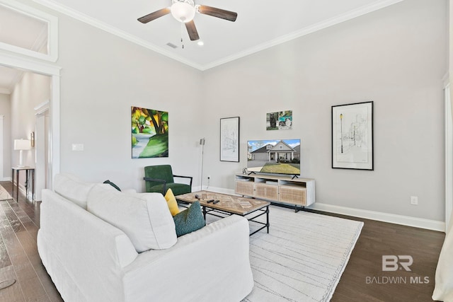 living room with crown molding, wood finished floors, baseboards, and visible vents