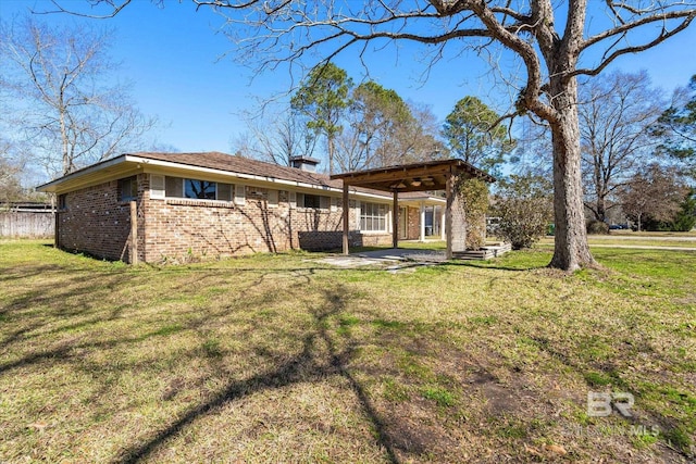 back of house featuring brick siding and a yard