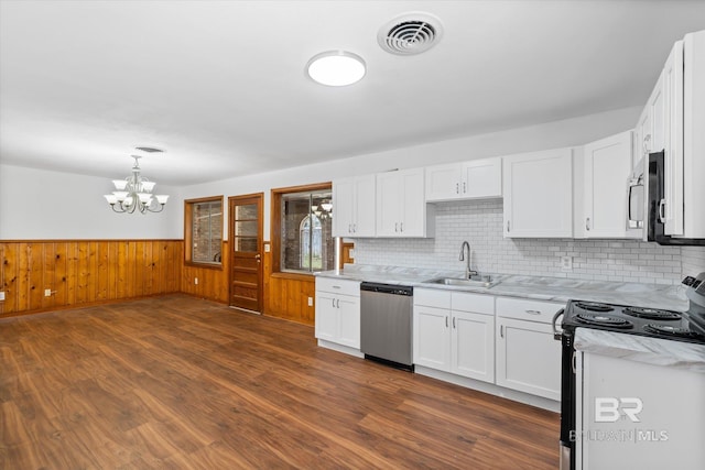 kitchen with dark wood finished floors, stainless steel appliances, visible vents, wainscoting, and a sink