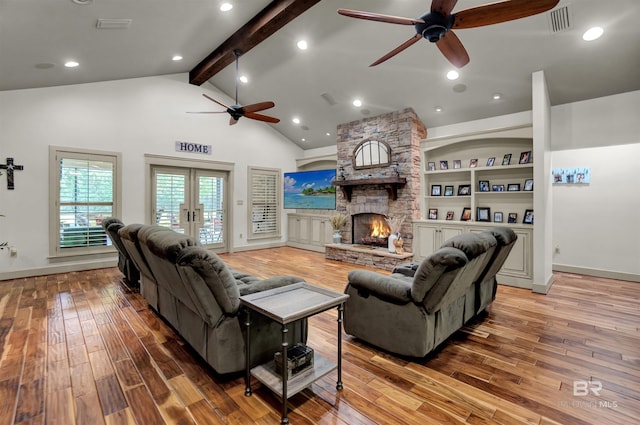 917 Rockaway Creek Rd, Atmore, AL 36502 - living room with beamed ceiling, visible vents, light wood finished floors, a ceiling fan, and a stone fireplace