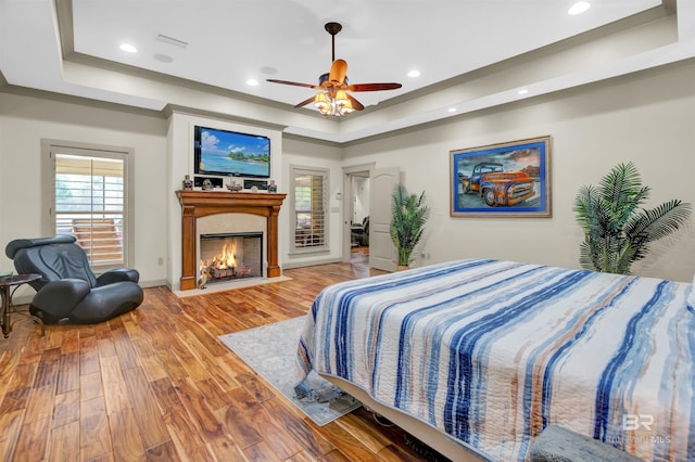 917 Rockaway Creek Rd, Atmore, AL 36502 - bedroom featuring recessed lighting, a fireplace with flush hearth, a raised ceiling, and light wood-type flooring