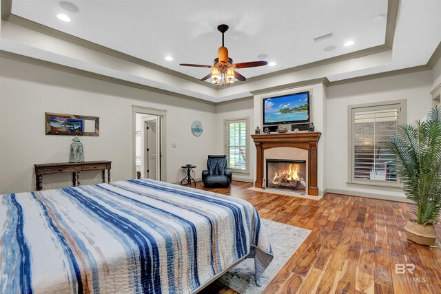 917 Rockaway Creek Rd, Atmore, AL 36502 - bedroom with recessed lighting, a fireplace with flush hearth, a tray ceiling, visible vents, and wood finished floors