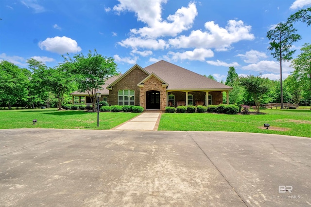 917 Rockaway Creek Rd, Atmore, AL 36502 - view of front of home with a front yard, a shingled roof, and brick siding