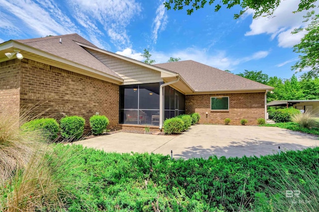 917 Rockaway Creek Rd, Atmore, AL 36502 - rear view of house with brick siding, roof with shingles, a sunroom, and a patio area