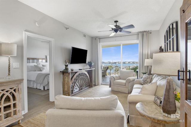 living room featuring a textured ceiling, ceiling fan, and light hardwood / wood-style floors