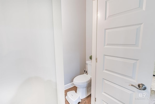 bathroom with hardwood / wood-style floors and toilet