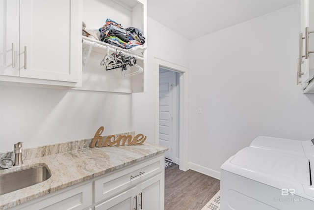 laundry area featuring cabinets, independent washer and dryer, dark hardwood / wood-style flooring, and sink