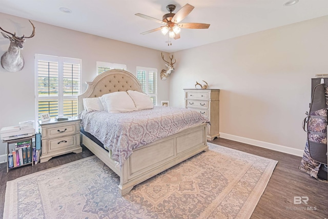 bedroom featuring ceiling fan, dark hardwood / wood-style flooring, and multiple windows