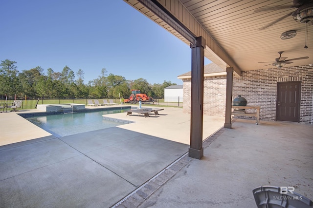 view of swimming pool with an in ground hot tub, a patio, and ceiling fan