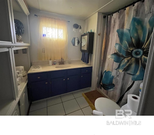 bathroom with toilet, a shower with curtain, vanity, and tile patterned floors