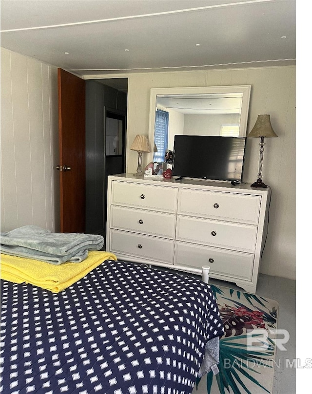 bedroom featuring wood walls