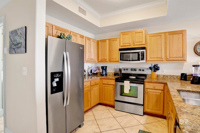 kitchen featuring light stone countertops, light brown cabinetry, appliances with stainless steel finishes, crown molding, and light tile patterned flooring