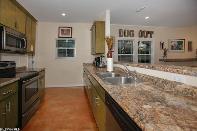 kitchen featuring light stone countertops, stainless steel appliances, kitchen peninsula, and sink