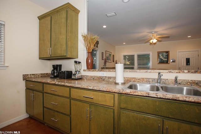 kitchen featuring stone counters, ceiling fan, and sink