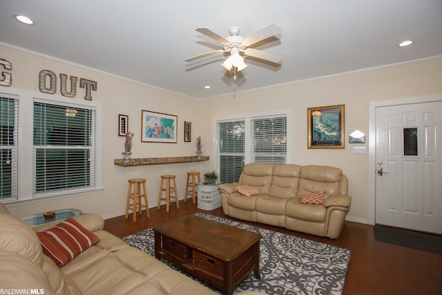 living room with ceiling fan, dark wood-type flooring, and ornamental molding