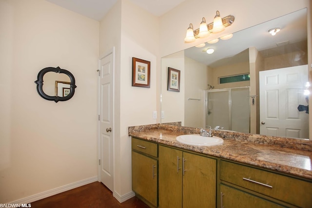 bathroom featuring a shower with shower door and vanity