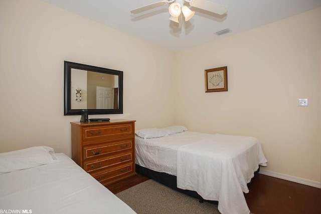 bedroom with dark hardwood / wood-style flooring and ceiling fan