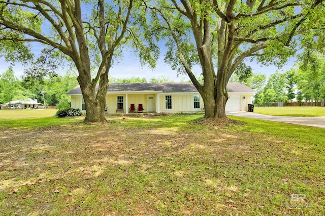 single story home featuring concrete driveway, fence, a front lawn, and a garage