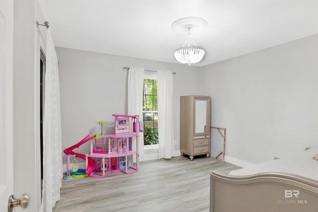 recreation room featuring baseboards and wood finished floors