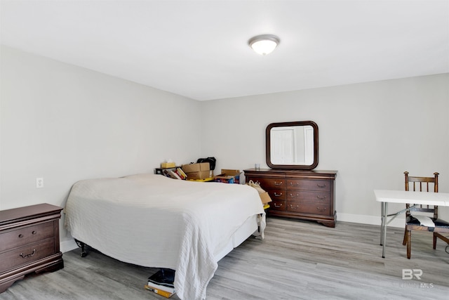 bedroom with wood finished floors and baseboards