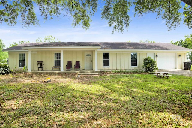 ranch-style home featuring driveway, board and batten siding, an attached garage, a front yard, and a porch