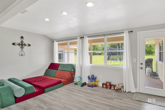 interior space with recessed lighting, access to exterior, multiple windows, and wood finished floors