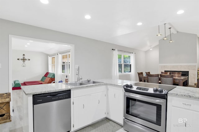 kitchen with a sink, appliances with stainless steel finishes, recessed lighting, and lofted ceiling