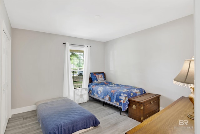 bedroom with a closet, baseboards, and wood finished floors