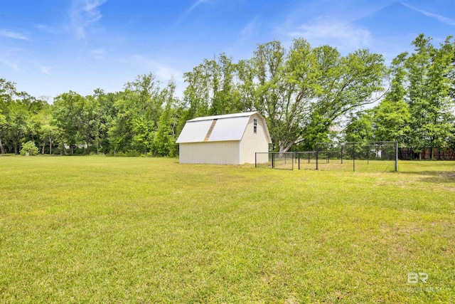 view of yard featuring an outdoor structure, fence, and an outbuilding