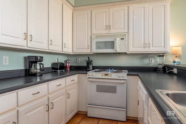 kitchen featuring white appliances, sink, and light tile flooring