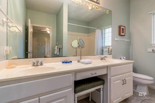 bathroom featuring ceiling fan, double sink vanity, toilet, and tile floors