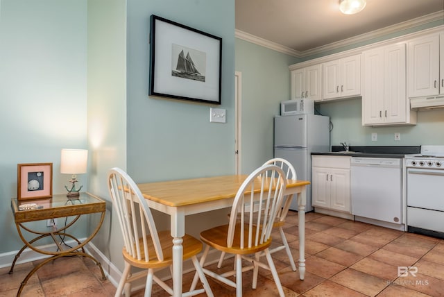 tiled dining space with crown molding and sink