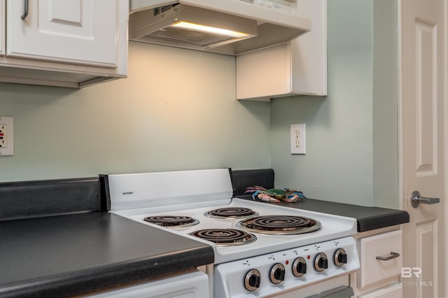 kitchen with white cabinetry, wall chimney range hood, and stove