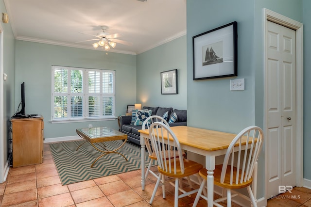 tiled dining room featuring ceiling fan and ornamental molding