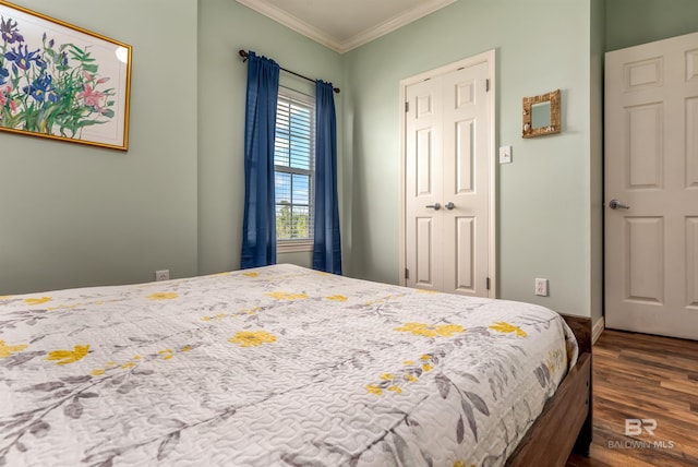 bedroom with dark hardwood / wood-style flooring, a closet, and crown molding