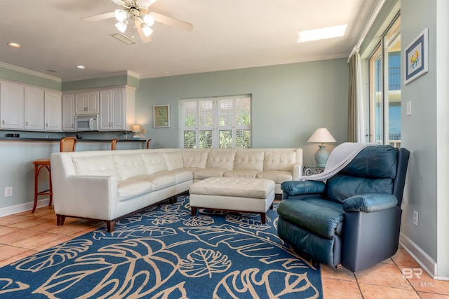 tiled living room featuring ceiling fan and ornamental molding