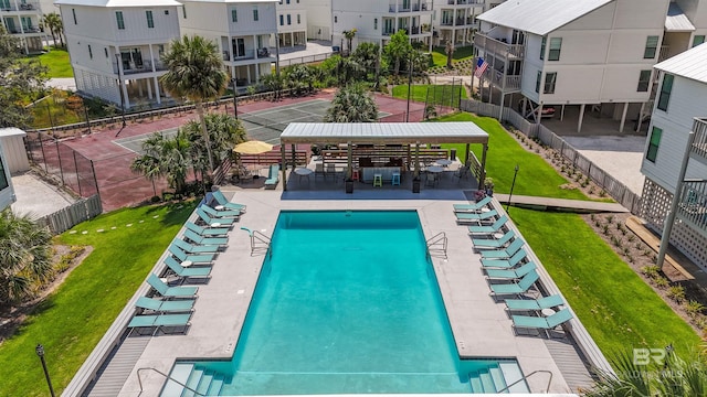 view of swimming pool featuring fence and a lawn