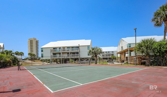 view of tennis court featuring community basketball court and fence