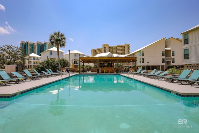 pool with a patio area and fence