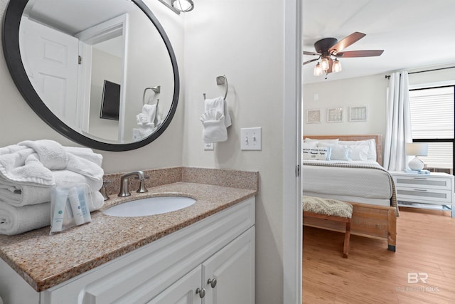 bathroom with vanity, a ceiling fan, and wood finished floors