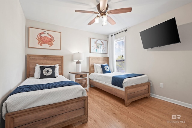 bedroom featuring light wood-style flooring, baseboards, and ceiling fan