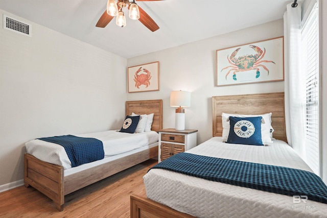 bedroom with wood finished floors, multiple windows, and visible vents