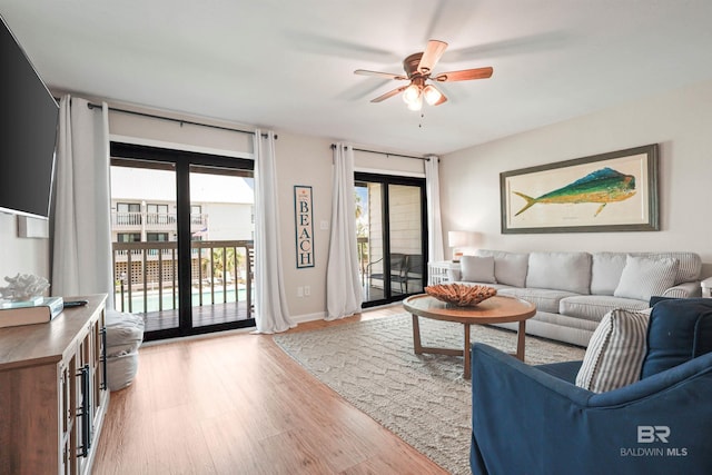 living room with light wood-style flooring and a ceiling fan
