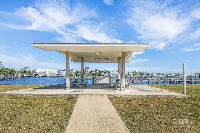 view of dock with a water view and a lawn