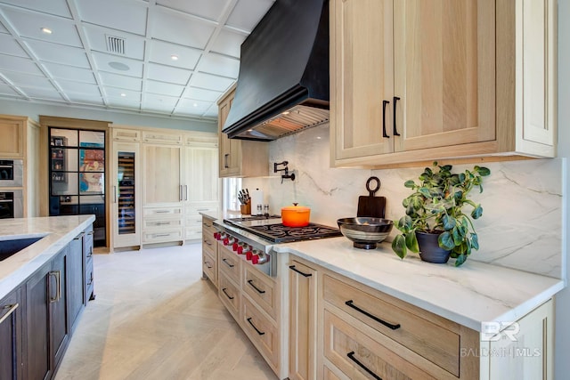 27269 Perdido Beach Blvd Unit C5A, Orange Beach, AL 36561 - kitchen with custom exhaust hood, gas stovetop, light stone countertops, black oven, and tasteful backsplash